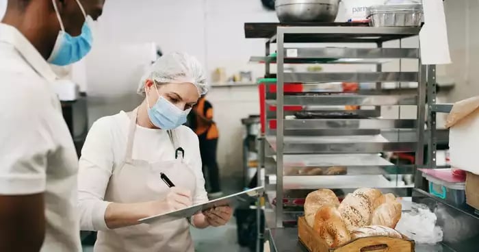 A staff member inspects kitchen inventory at a restaurant