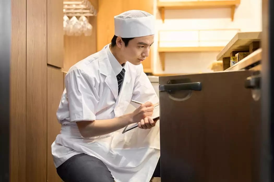 A Japanese sushi chef takes inventory in prep for inventory variance analysis.