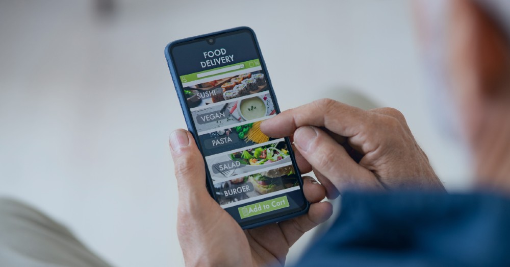 Person ordering food using ordering app on cell phone